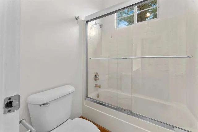 an empty room with wooden floor and window