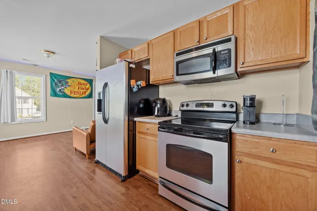 a kitchen with stainless steel appliances granite countertop a stove a microwave and a refrigerator