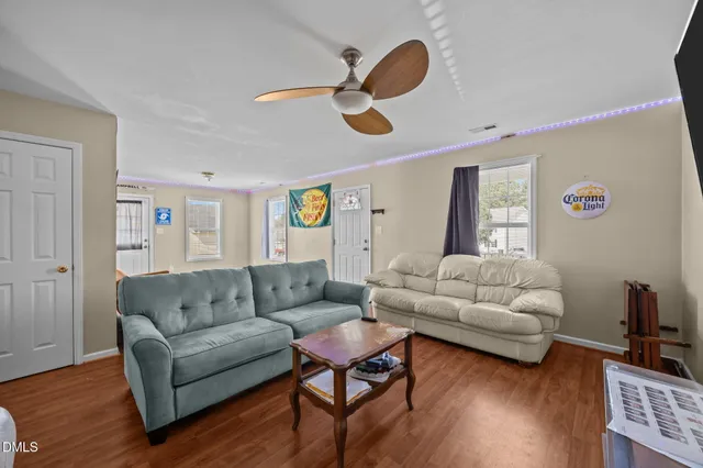 a living room with furniture and a wooden floor