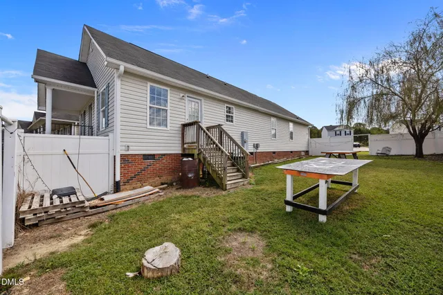 a view of a house with backyard and a tree