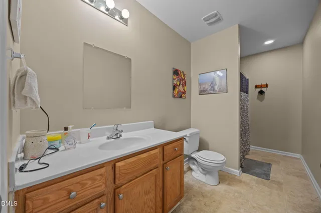 a bathroom with a granite countertop toilet sink and mirror