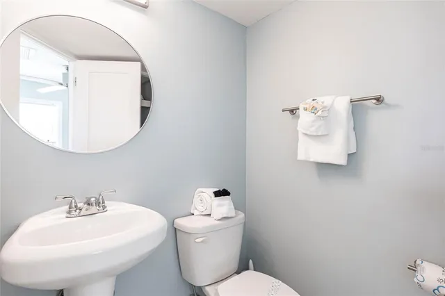 a bathroom with a sink mirror and toilet