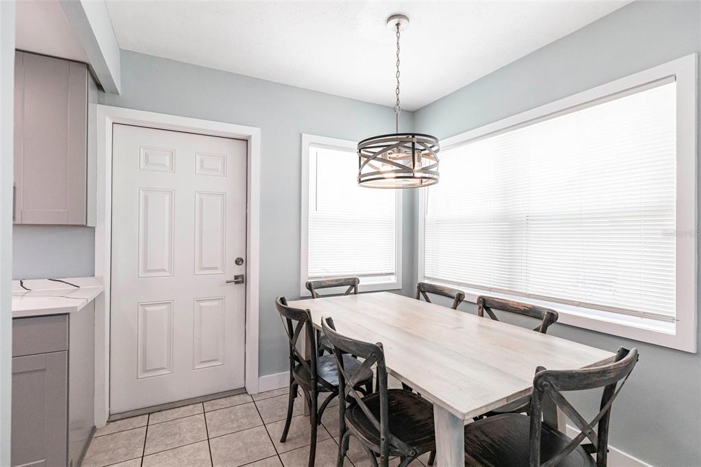6020 Midnight Pass Road, Unit 49 Sarasota, FL 34242 - Photo 10 of 38 a view of a dining room with furniture window and wooden floor