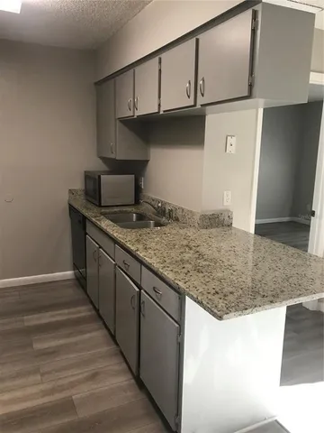 a kitchen with granite countertop a sink and a stove
