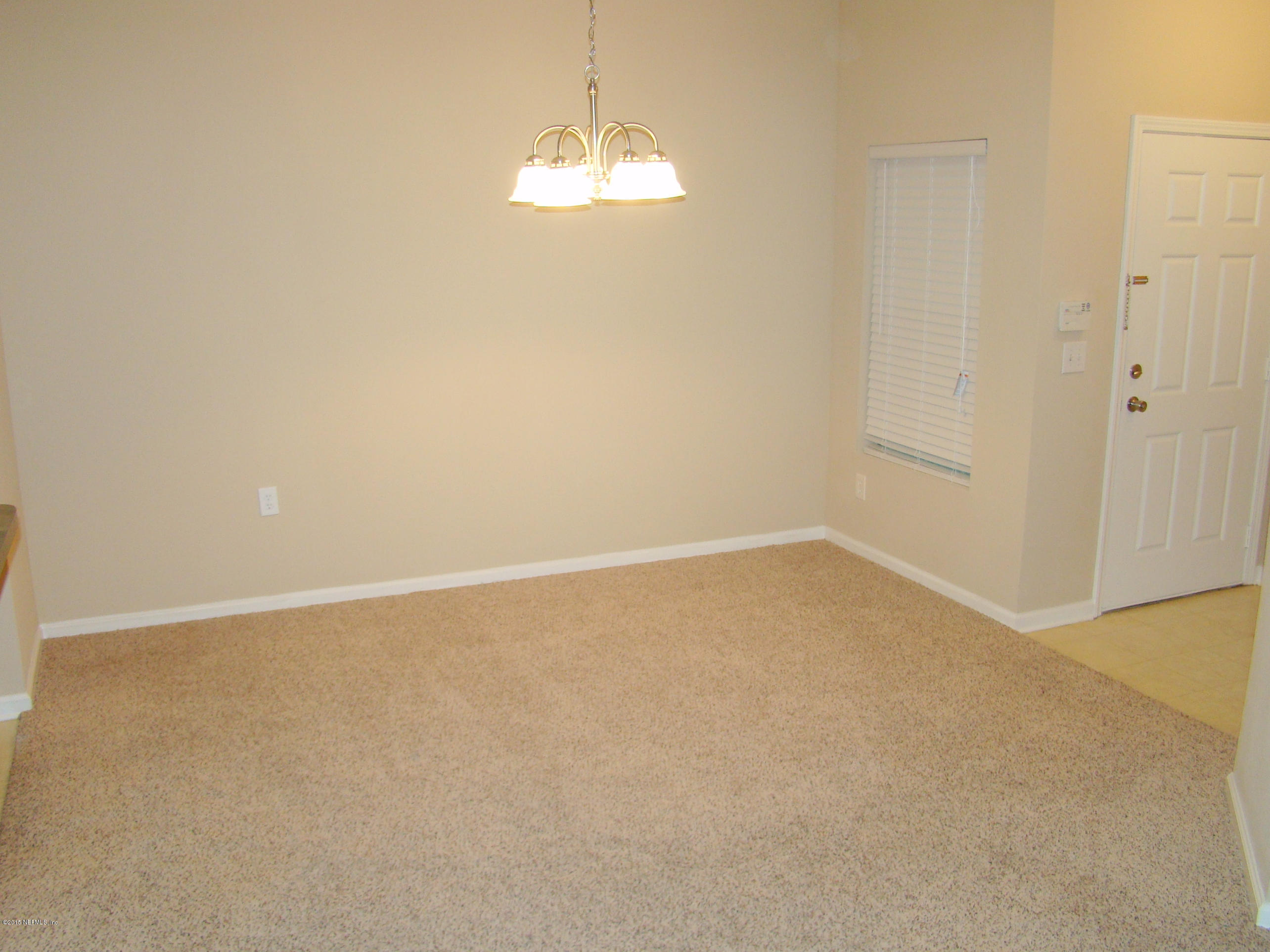 7920 Merrill Road, Unit 1504 Jacksonville, FL 32277 - Photo 3 of 12 a view of an empty room with a chandelier fan
