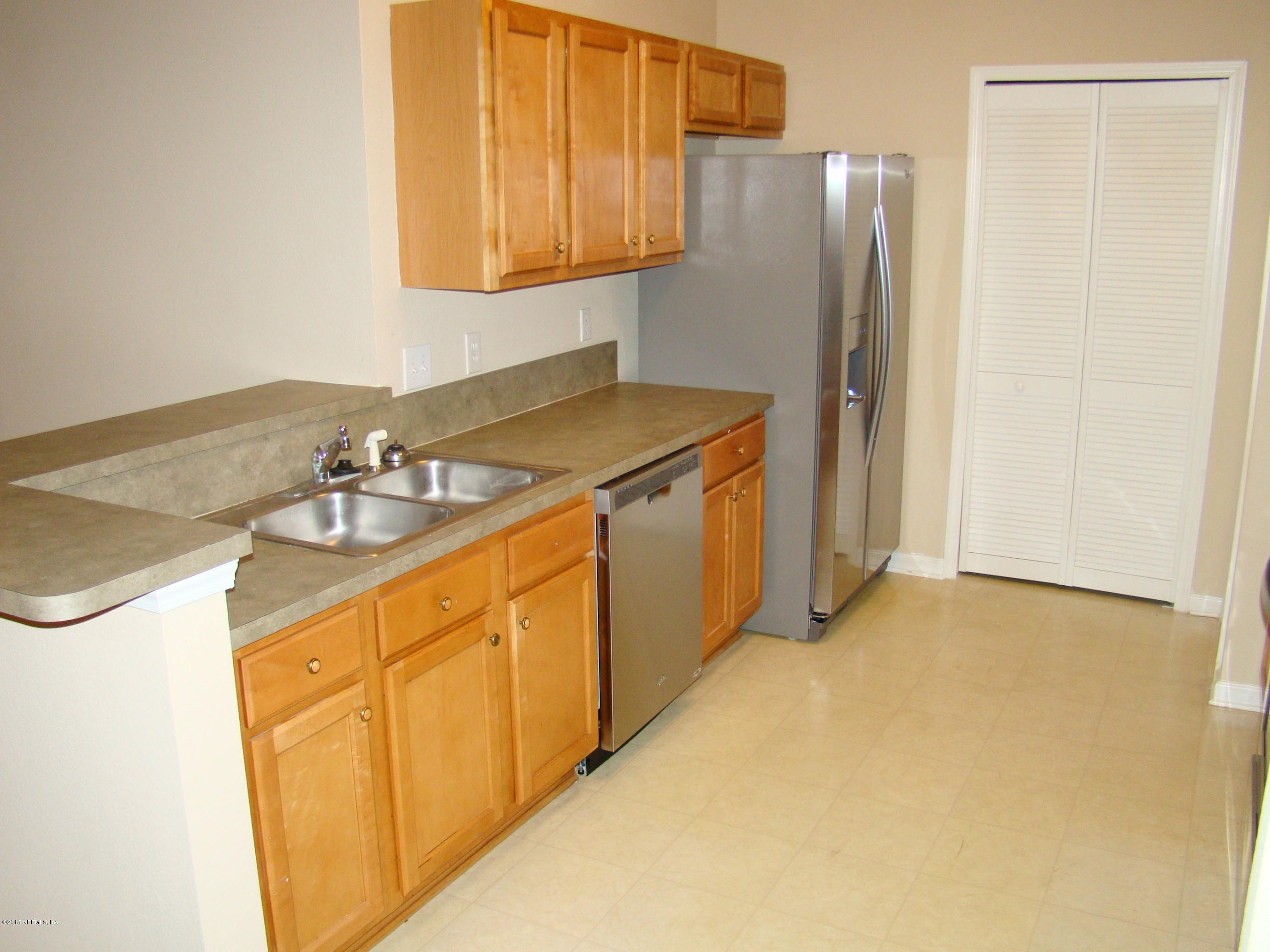 7920 Merrill Road, Unit 1504 Jacksonville, FL 32277 - Photo 4 of 12 a kitchen with stainless steel appliances granite countertop a refrigerator and a sink