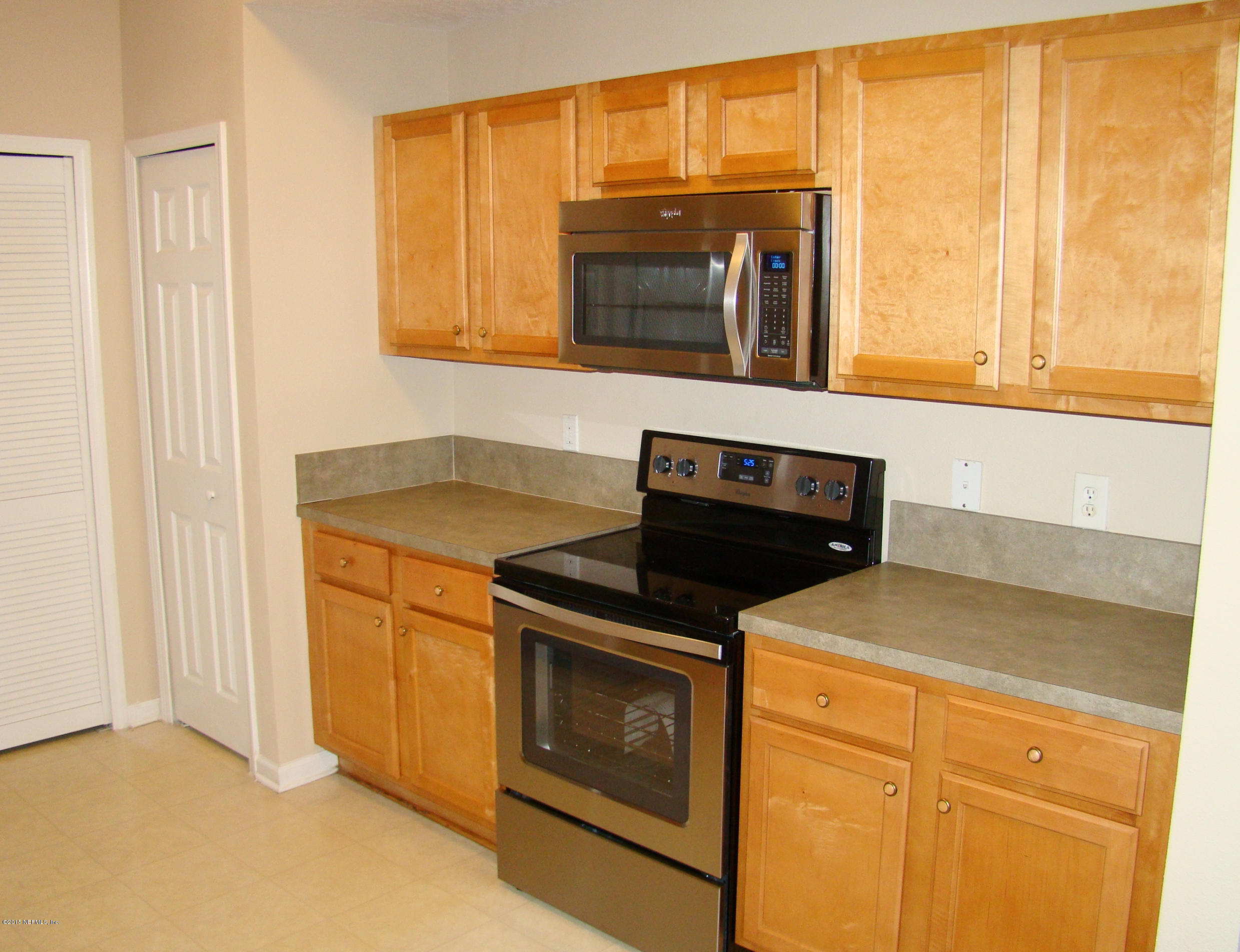 7920 Merrill Road, Unit 1504 Jacksonville, FL 32277 - Photo 5 of 12 a kitchen with a stove and a microwave