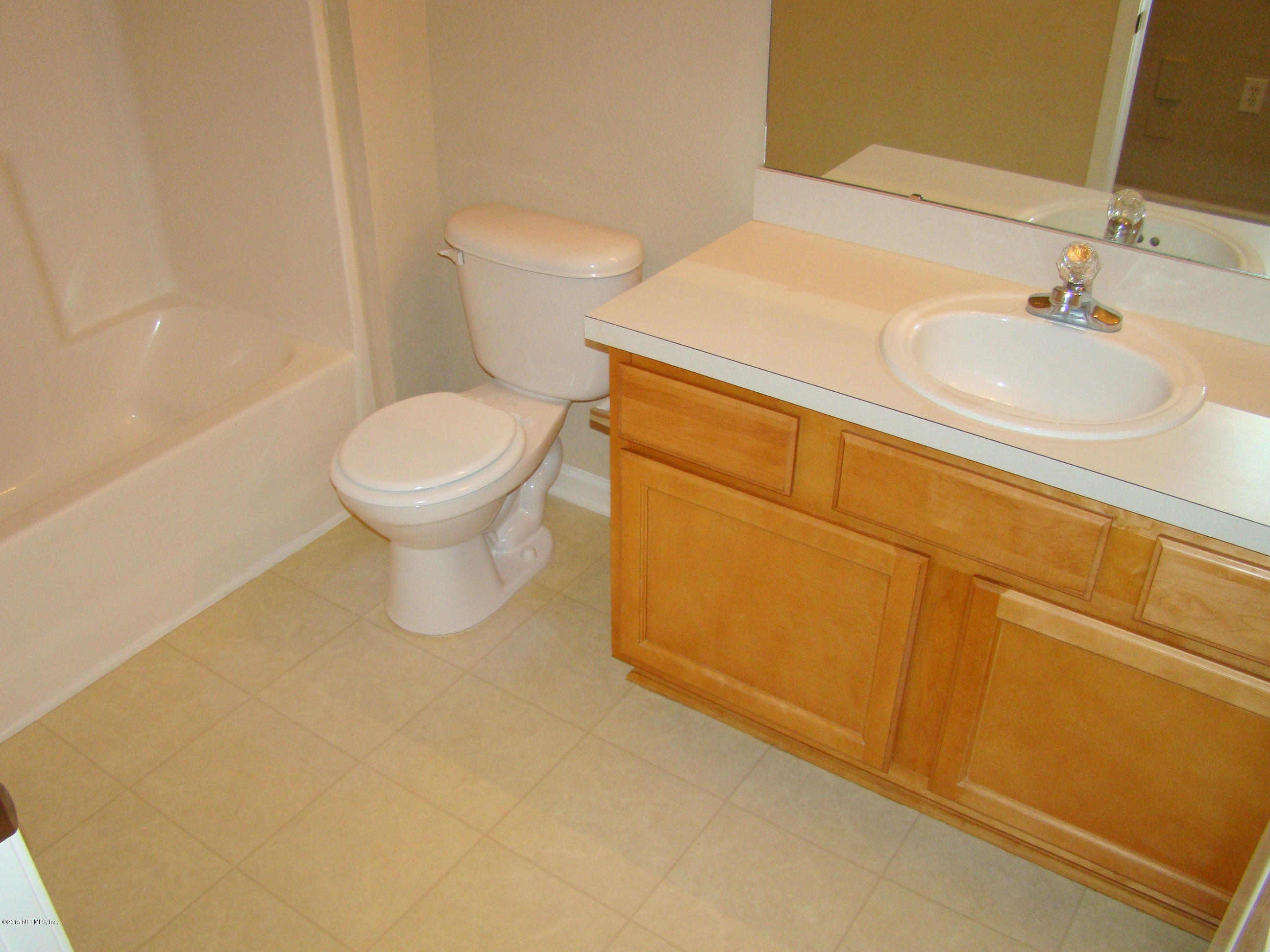 7920 Merrill Road, Unit 1504 Jacksonville, FL 32277 - Photo 10 of 12 a bathroom with a toilet sink and mirror