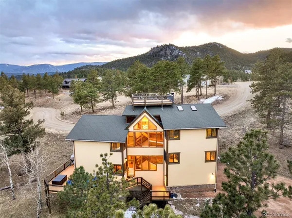 an aerial view of house with yard and mountain view in back