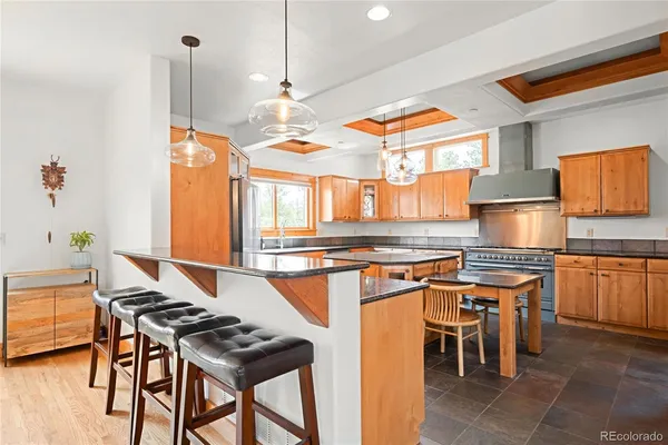 a kitchen with stainless steel appliances granite countertop a stove a sink and a refrigerator