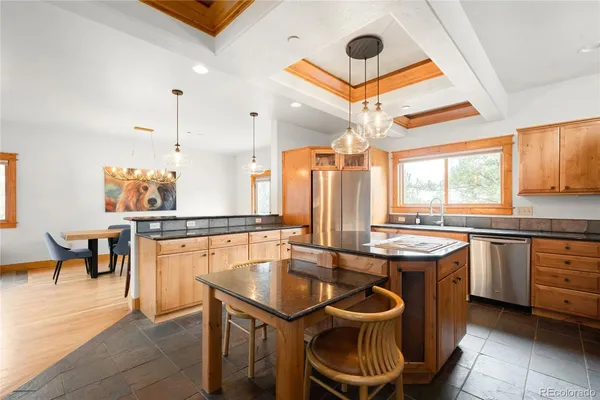 a kitchen with stainless steel appliances granite countertop a stove a sink and a refrigerator