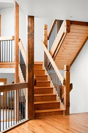 a view of staircase with lots of frames on wall and wooden floor