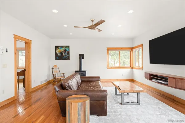 a living room with furniture a flat screen tv and wooden floor