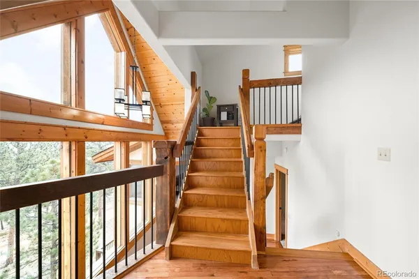 a view of staircase with wooden floor and white walls