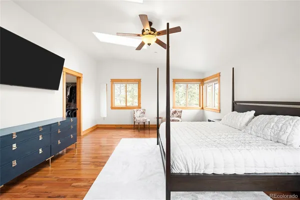 a bedroom with a bed and a flat tv screen on dresser