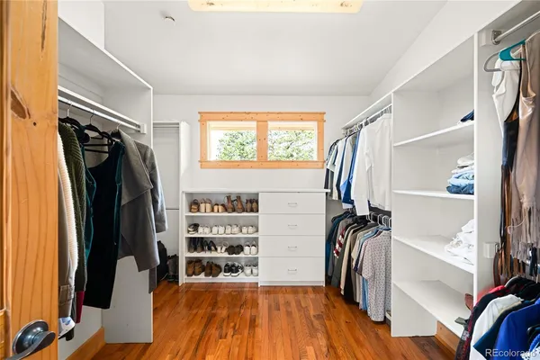 a view of walk in closet with clothes and shoes