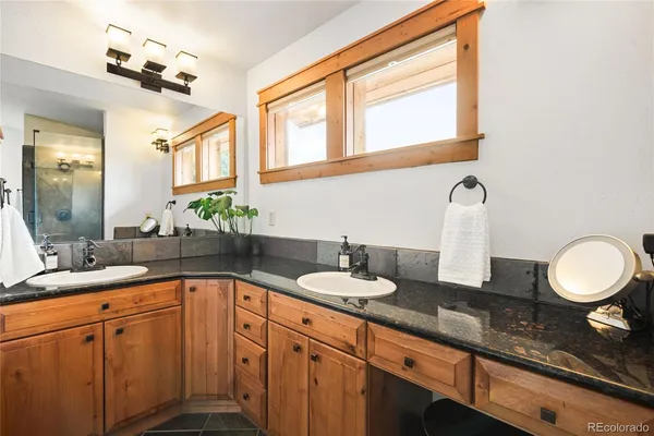 a bathroom with a granite countertop sink and a mirror