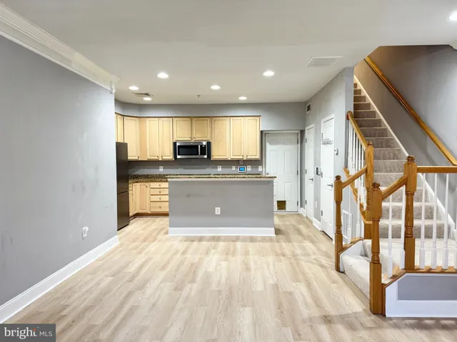 a kitchen with stainless steel appliances granite countertop a refrigerator a sink and a stove