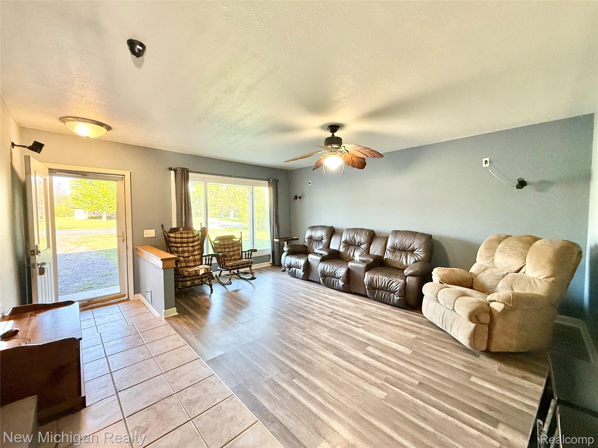 5288 Torrey Road Flint, MI 48507 - Photo 5 of 41 Living area with light wood-style floors, a textured ceiling, and a ceiling fan