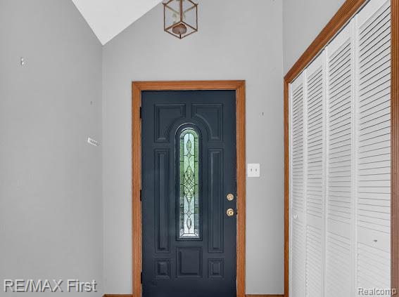 56375 Bates Road New Baltimore, MI 48051 - Photo 11 of 35 Dark-paneled front door with decorative glass insert, wood-finish door frame, and brass hardware