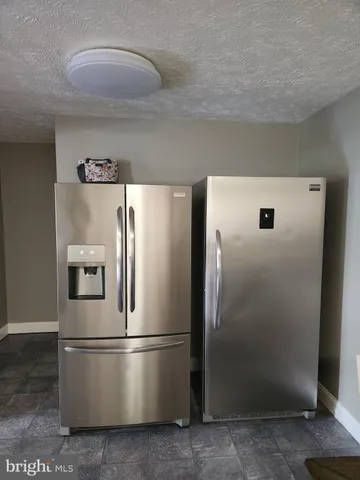 a metallic refrigerator freezer sitting in a kitchen