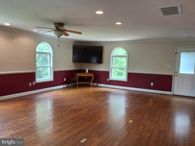 a view of a livingroom with furniture a flat screen tv and wooden floor