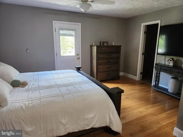 a bedroom with a bed and a flat tv screen on a dresser