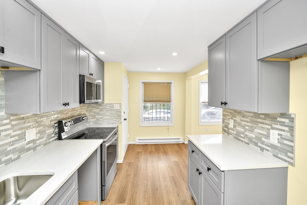 11 Greendale Road, Unit 2 Boston, MA 02126 - Photo 8 of 25 a kitchen with a sink stove and cabinets