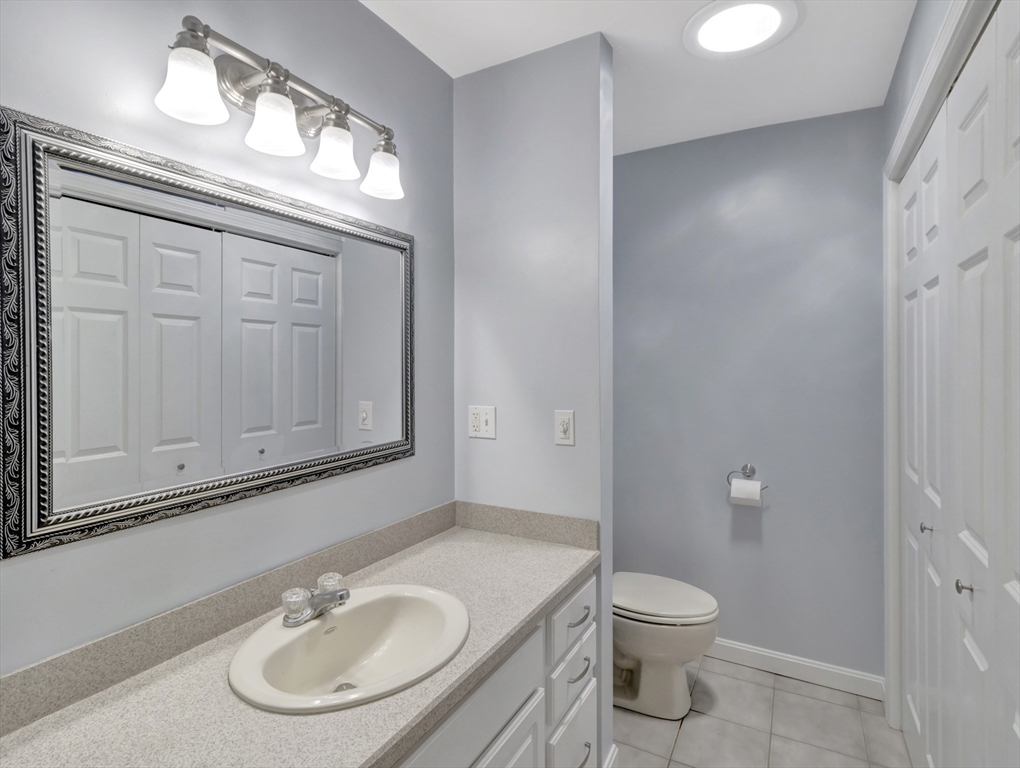 13 Shawmut Avenue, Unit 13 Mansfield, MA 02048 - Photo 17 of 34 a bathroom with a toilet a sink a mirror and vanity