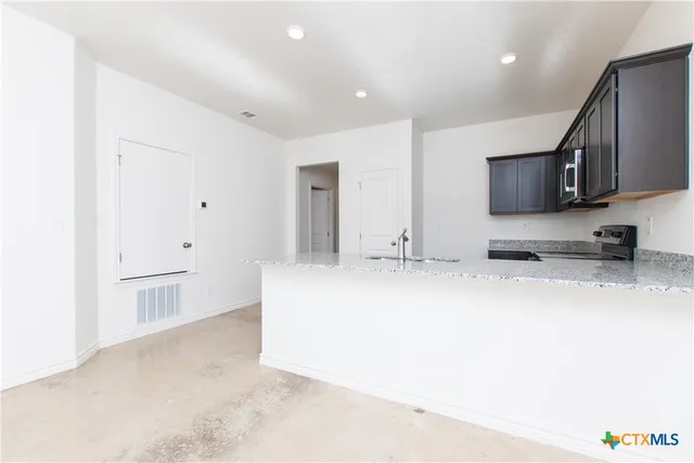 a view of kitchen cabinets and stainless steel appliances