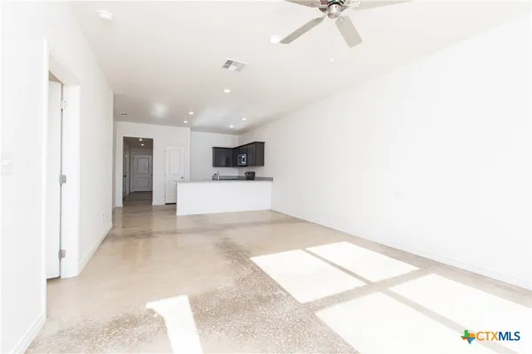 a view of a hallway with a stove and a microwave