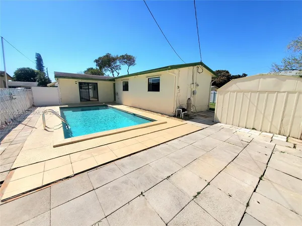 a backyard of a house with table and chairs