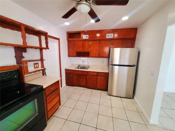 a kitchen with stainless steel appliances granite countertop a refrigerator a sink and a stove