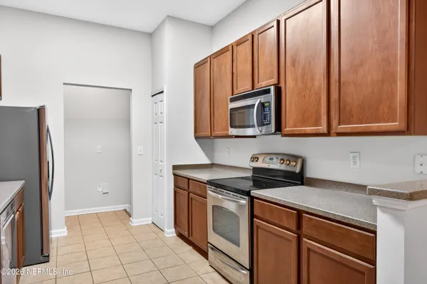 a kitchen with stainless steel appliances granite countertop a refrigerator a stove a sink and dishwasher