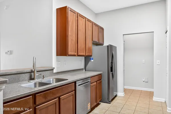 a kitchen with stainless steel appliances granite countertop a sink and a refrigerator