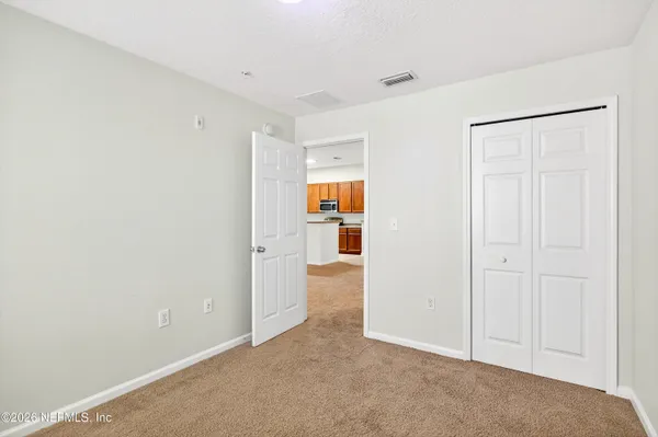 an empty room with windows and closet