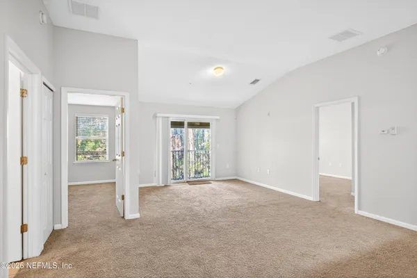 an empty room with windows and entrance