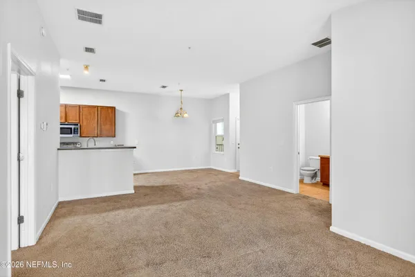a view of an empty room with a kitchen