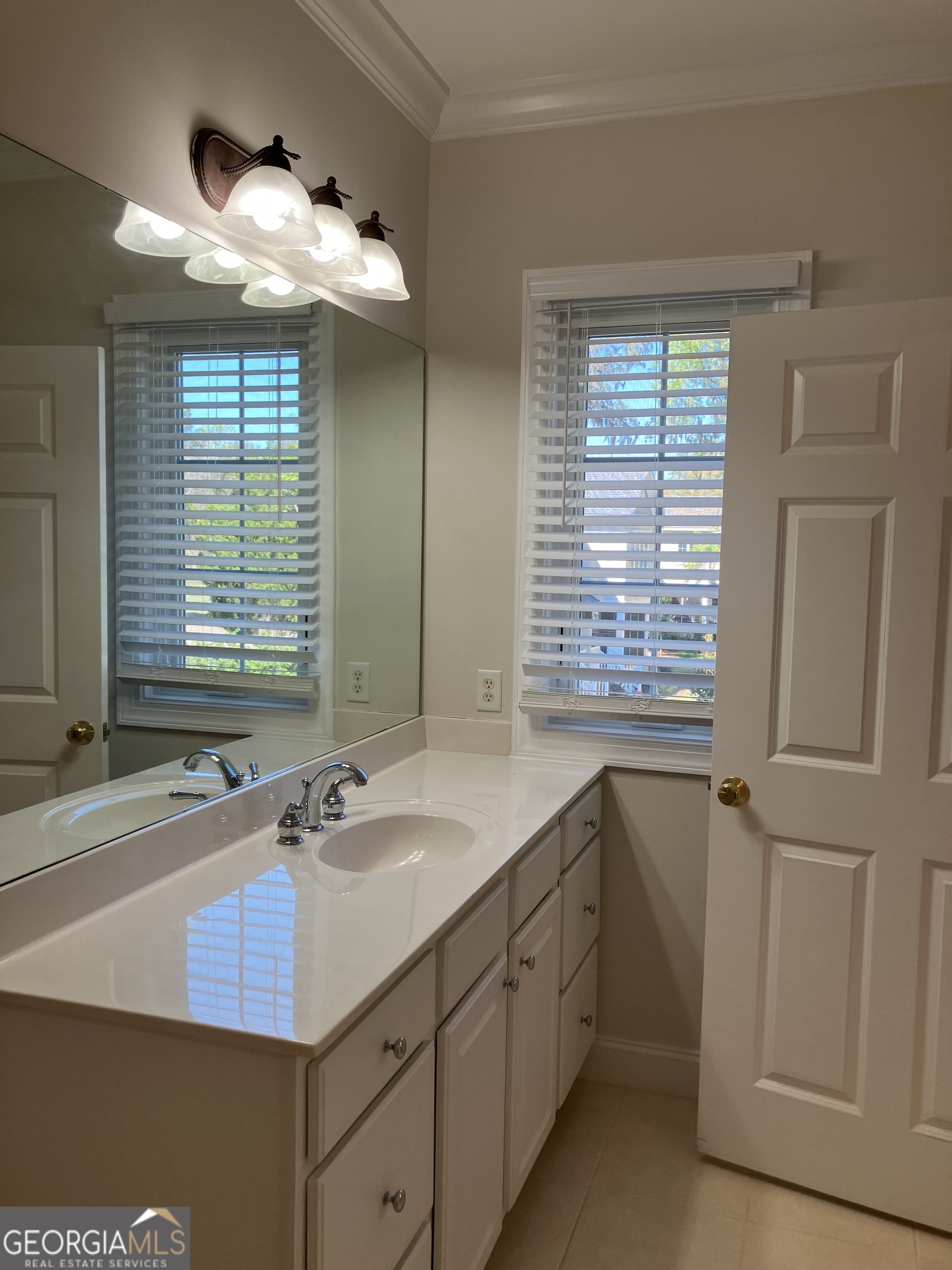 103 Kiln Trail St. Simons Island, GA 31522 - Photo 50 of 81 a bathroom with a sink a large mirror and a window