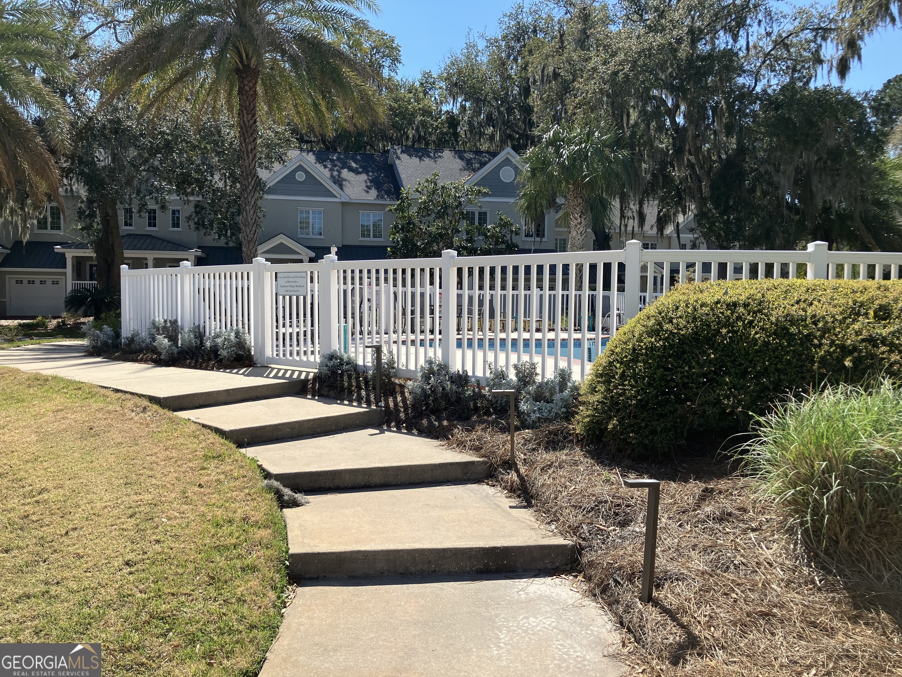 103 Kiln Trail St. Simons Island, GA 31522 - Photo 74 of 81 a view of a backyard with brick wall and potted plants