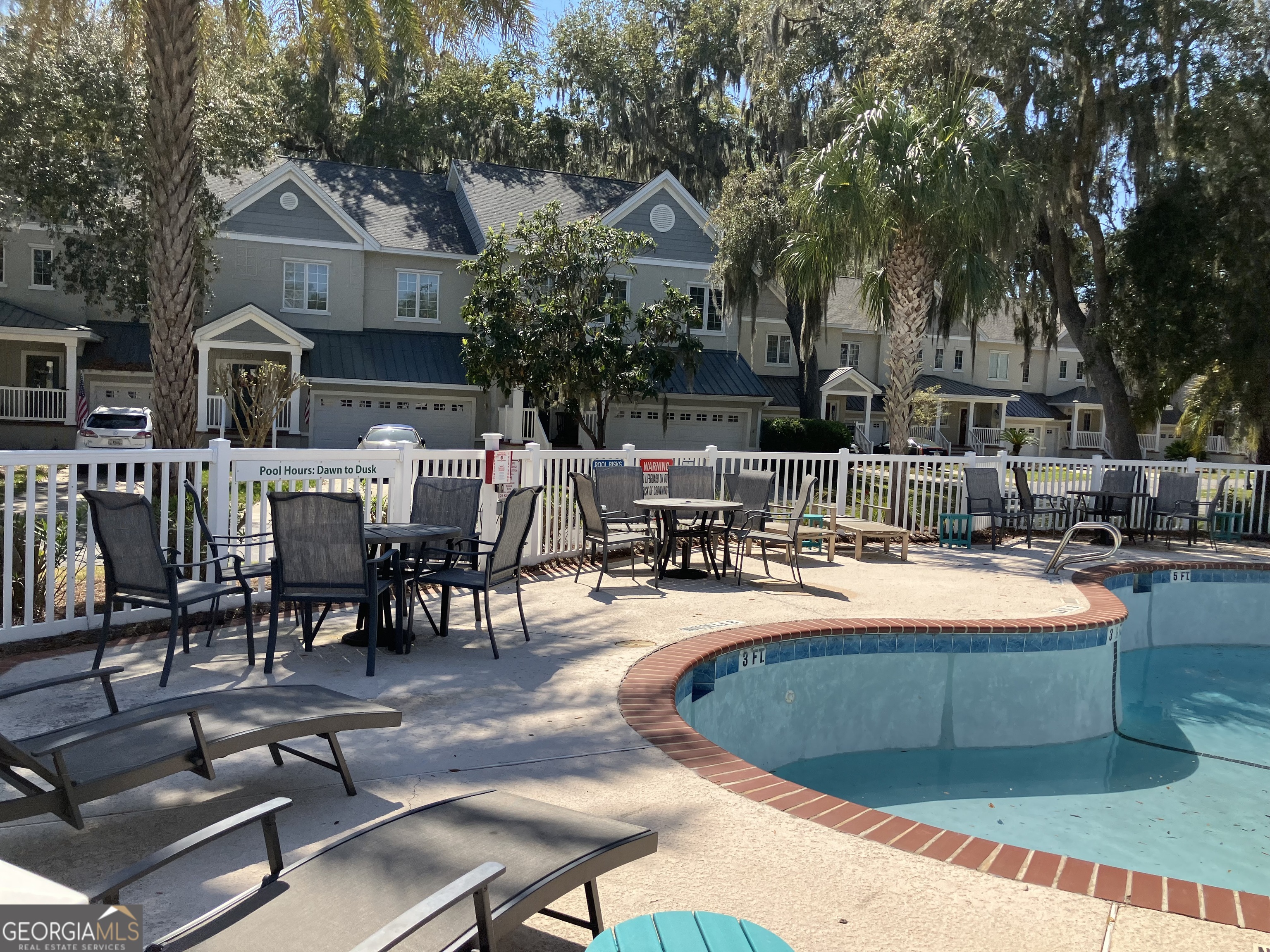 103 Kiln Trail St. Simons Island, GA 31522 - Photo 76 of 81 a view of a swimming pool with chairs and tables