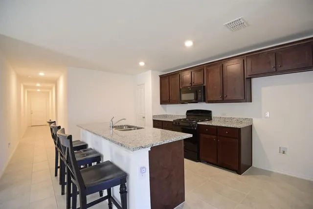a kitchen with a sink cabinets and wooden floor