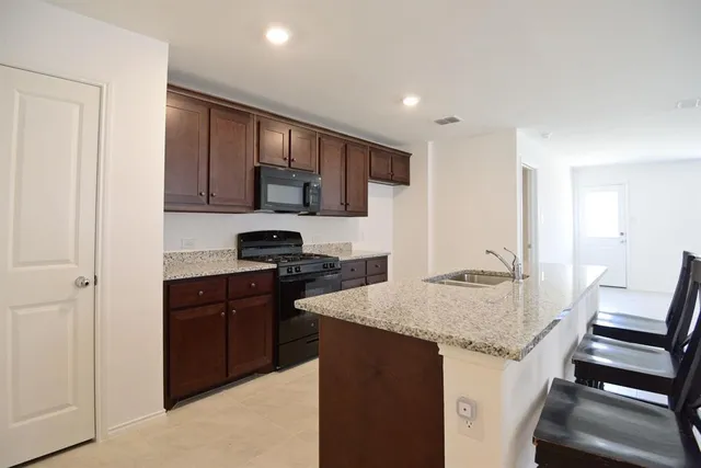 a kitchen with a sink stove and cabinets