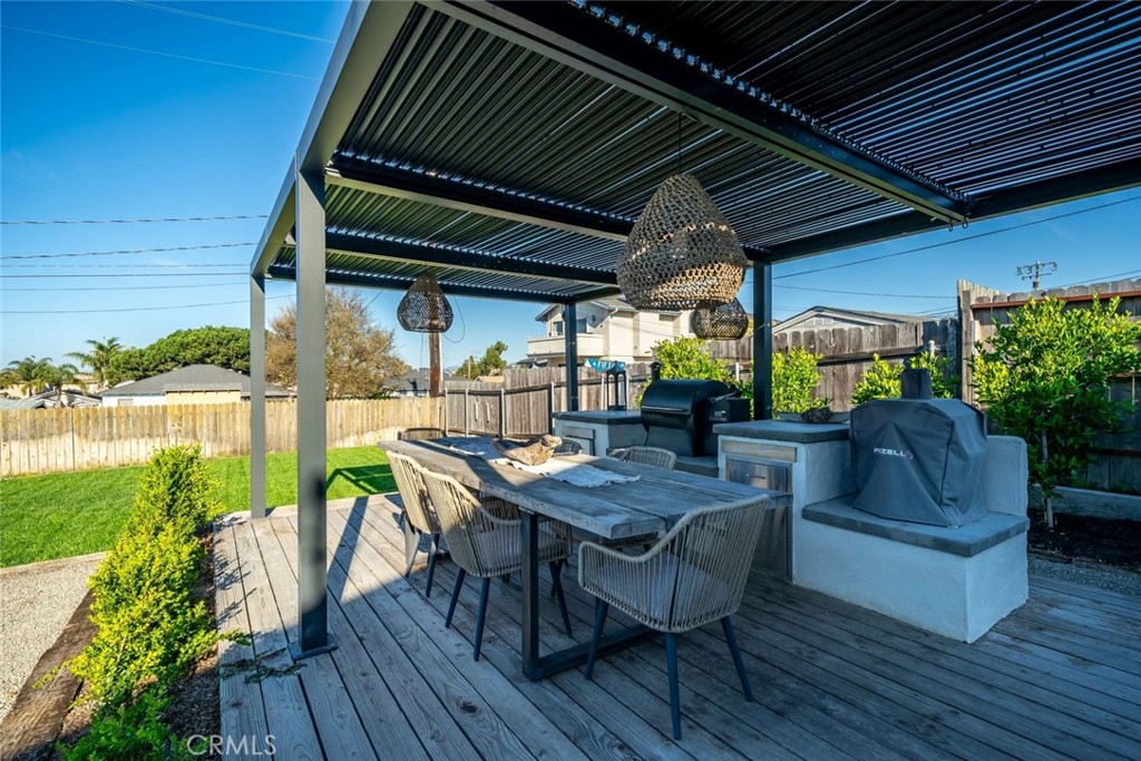 363 North 5th Street Grover Beach, CA 93433 - Photo 43 of 54 a view of patio with table and chairs potted plants and wooden floor