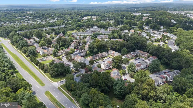 an aerial view of residential houses with outdoor space and trees