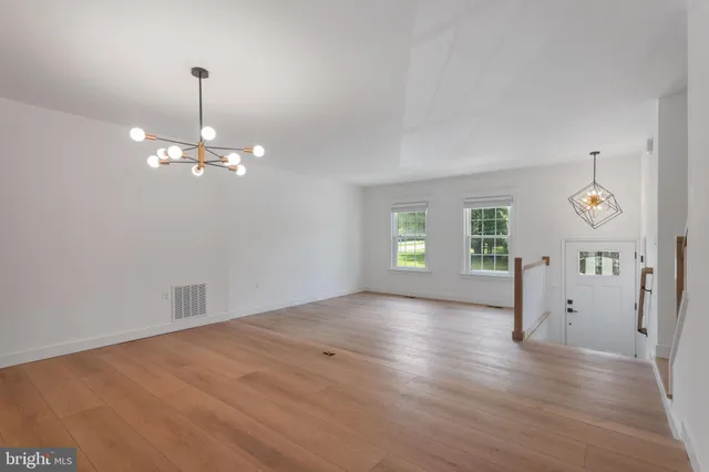 an empty room with window and wooden floor