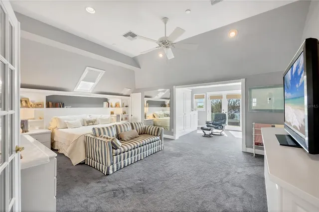 a work room with furniture a flat screen tv and a large window