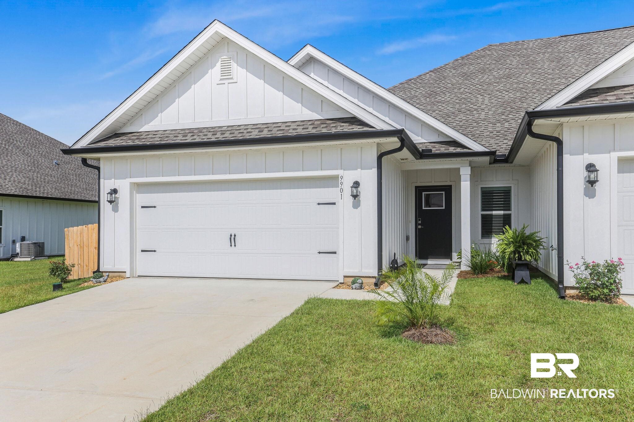9901 Weller Cove Foley, AL 36535 - Photo 1 of 23 Ranch-style home featuring a shingled roof, a garage, board and batten siding, and a front lawn