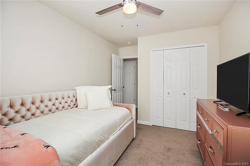 2139 Midnight Blue Lane Fort Mill, SC 29708 - Photo 10 of 23 a bedroom with a bed and a flat tv screen on a dresser