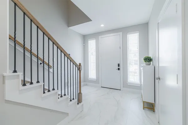 a view of a hallway with entryway and stairs